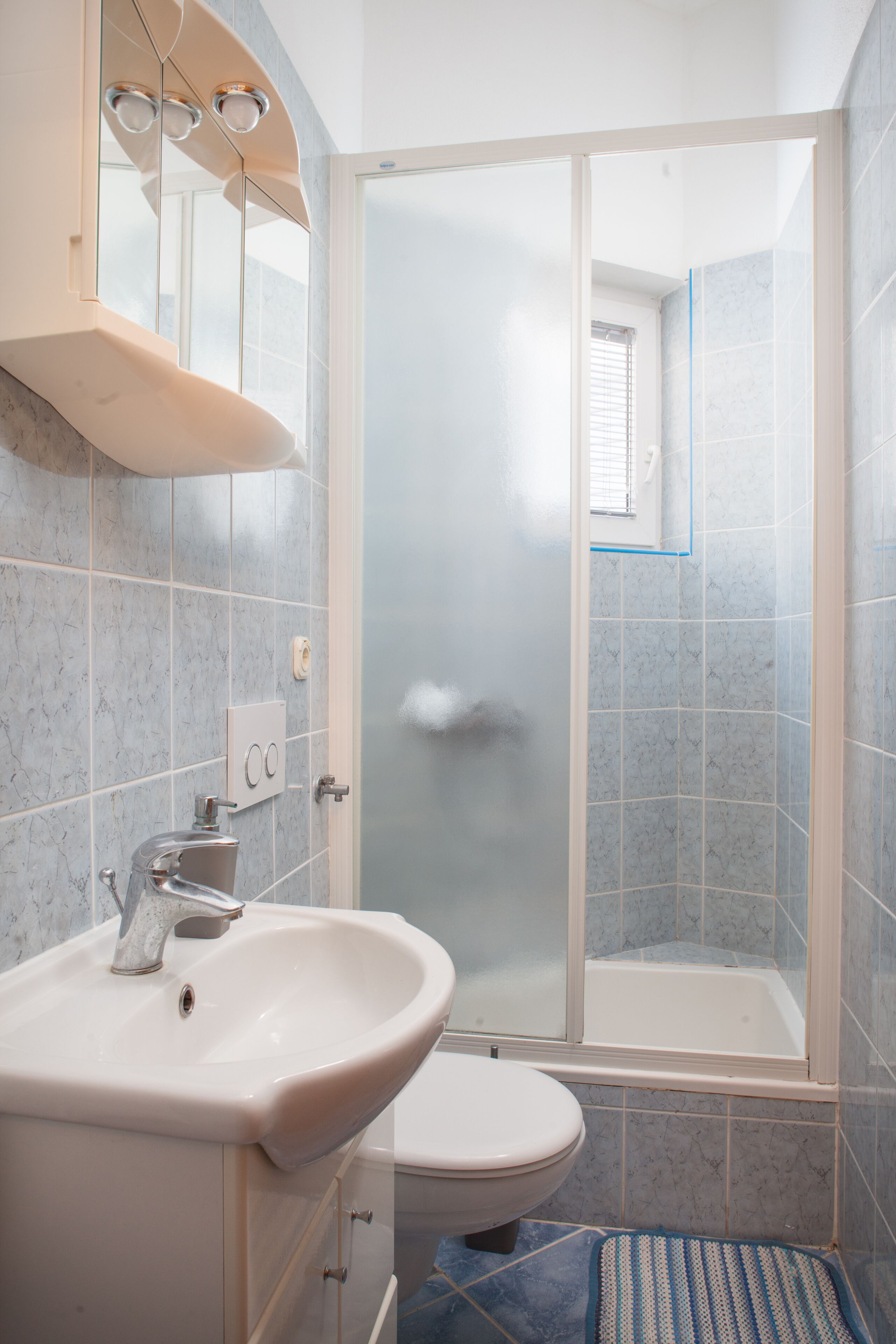 Un baño con lavamanos, inodoro y ducha.