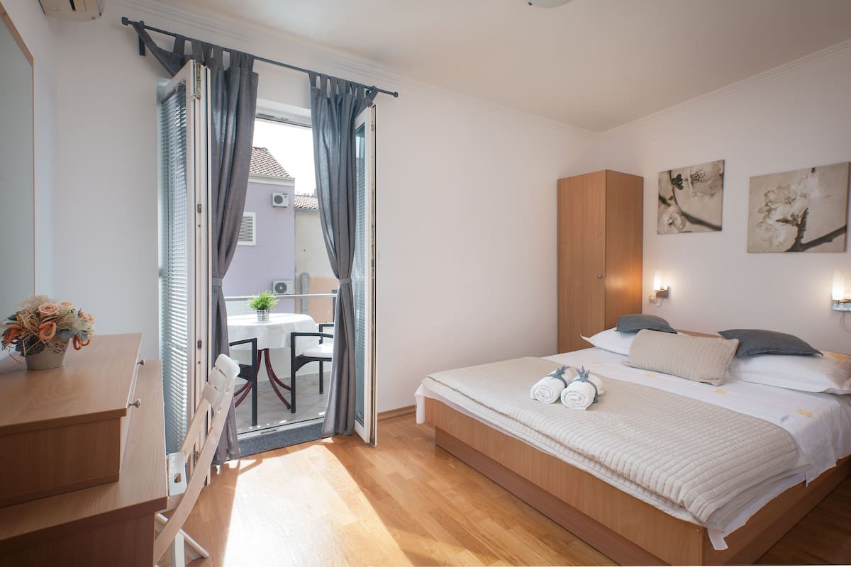 A bedroom with a bed, a desk, and a chair.