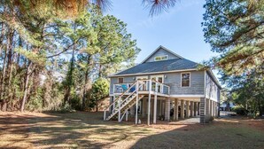 A two-story house with a covered porch and a staircase leading to the entrance. - A Some Place Special Minutes to Beach Sleeps 10 (Pawleys Island)