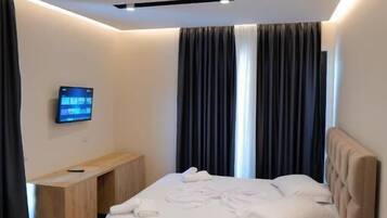 Una habitación de hotel moderna con cama, escritorio y televisión.
