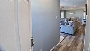 A hallway leading to a living area with a sofa and a dining table. - Stunning Renovations, Top Floor Views, and less than 2 Blocks to the Beach! (Wildwood)