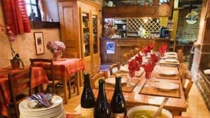 A dining area with a long table set for a meal, featuring various dishes and bottles. - Cottages, bed and breakfasts in the heart of the North Finistère countryside. (Plouégat-Moysan)