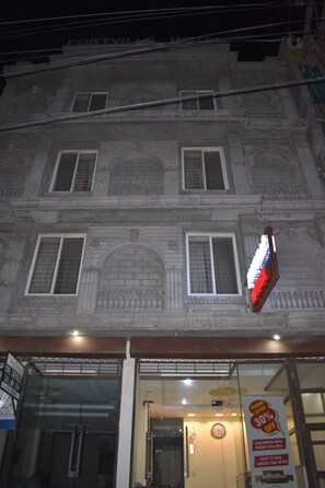 A hotel facade with a large illuminated sign advertising a 30% discount.