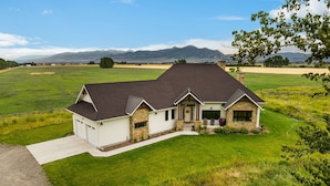 A single-story house with a stone facade, a dark roof, and a front porch.