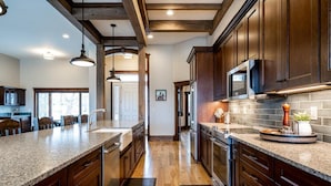 A spacious kitchen with dark wooden cabinets, granite countertops, and stainless steel appliances.