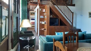 A cozy living room with a staircase, a television, and a dining area. - PRIVATE RURAL HOUSE WITH POOL (Los Llanos)