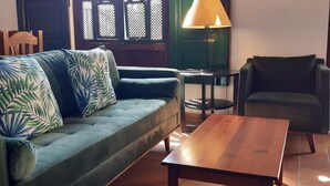 A living room with a green sofa, a wooden coffee table, a lamp, and a chair. - PRIVATE RURAL HOUSE WITH POOL (Los Llanos)