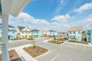 A residential area with multiple two-story houses, a parking lot, and a clear sky. - Disney near Resort: 2BR Cottage w Private Pool (Kissimmee)