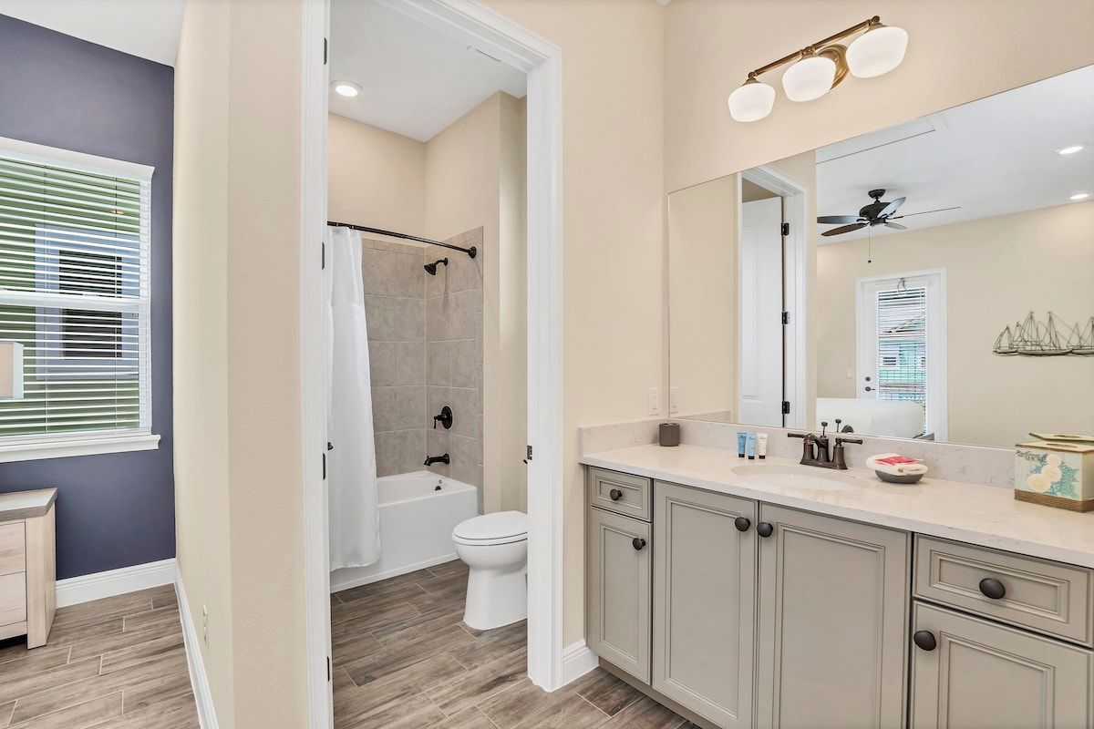 Une salle de bain avec douche, toilettes et un meuble-lavabo avec miroir.