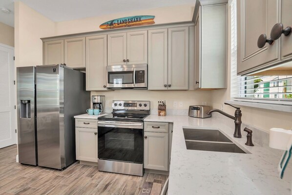 A modern kitchen with stainless steel appliances, a built-in oven, and a microwave.