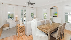 A modern, well-lit room with a wooden dining table, white upholstered chairs, and a large mirror. - Private Pool And Gulf Views- Sugar Magnolia By Royal Destinations (Santa Rosa Beach)