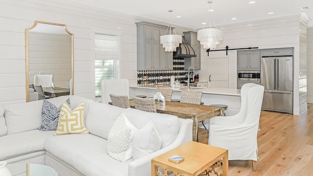 A modern living room with a white sofa, a wooden coffee table, and a dining area with a wooden table and chairs. - Private Pool And Gulf Views- Sugar Magnolia By Royal Destinations (Santa Rosa Beach)