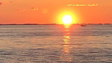 A sunset over a calm sea with a clear horizon.