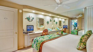 A bedroom with a bed, a desk, a chair, a mirror, and a ceiling fan. - Kaleialoha 106 Ocean Front 1bd/1ba 1 Bedroom Condo by RedAwning (Lahaina)