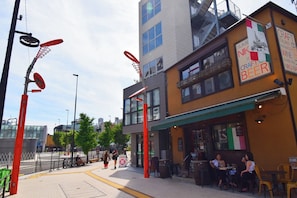 Une vue d’une rue où l’on aperçoit un restaurant appelé « NIK », qui propose une cuisine italienne et sert de la bière.