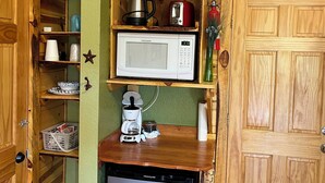 A compact kitchen with a microwave, coffee maker, and a small refrigerator. - Mountain Peaks Inn, GREEN MOUNTAIN SUITE, Downtown Hill City (Hill City)