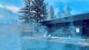 A swimming pool with lounge chairs and a building with a modern design. - Fully Renovated Aspen Core 2/2 w A/C on River! (Aspen)