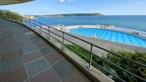 Ein Pool mit Blick auf das Meer und eine entfernte Insel.
