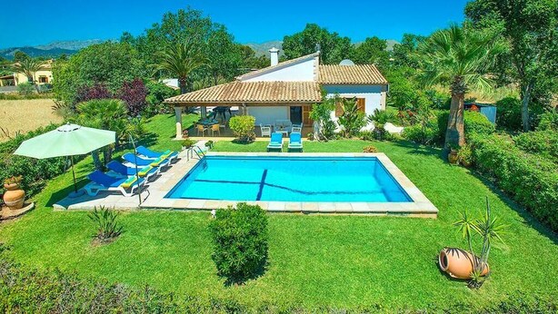 A house with a swimming pool, surrounded by a well-maintained lawn and various plants. - Villa Geranios, country house a few minutes driving from Pollensa (Pollença)