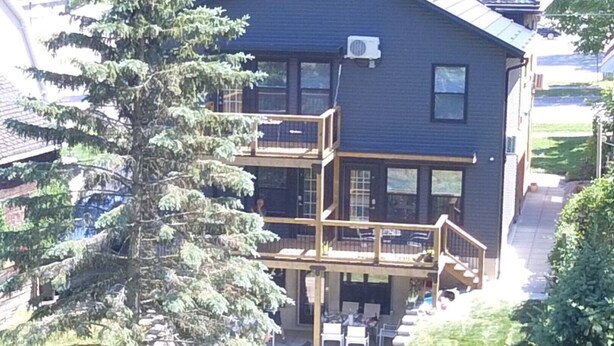 A two-story building with a balcony and outdoor seating area.
