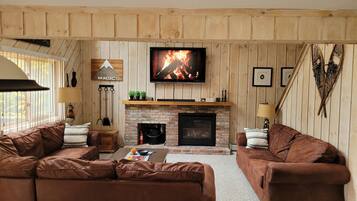 Smart-tv, een open haard, boeken en een stereo