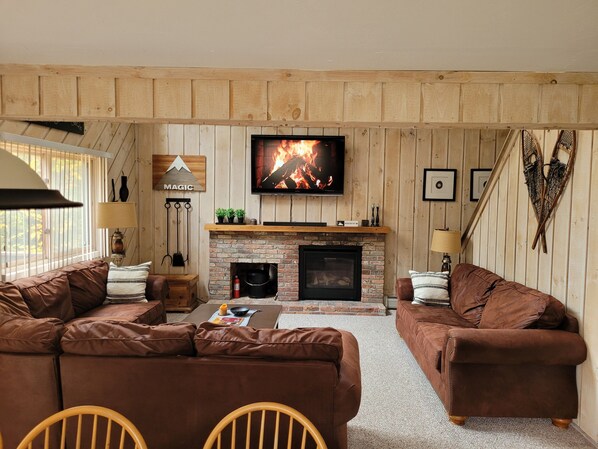 TV connectée, cheminée, livres, chaîne hi-fi