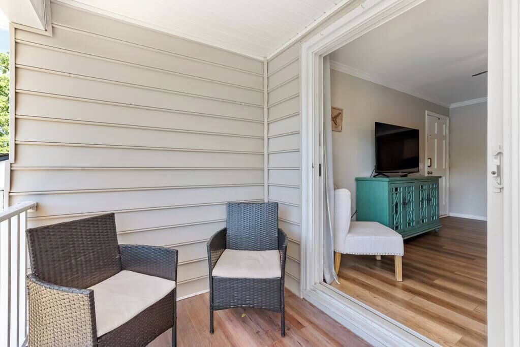 A balcony with wicker furniture, a television, and a teal cabinet in the background.