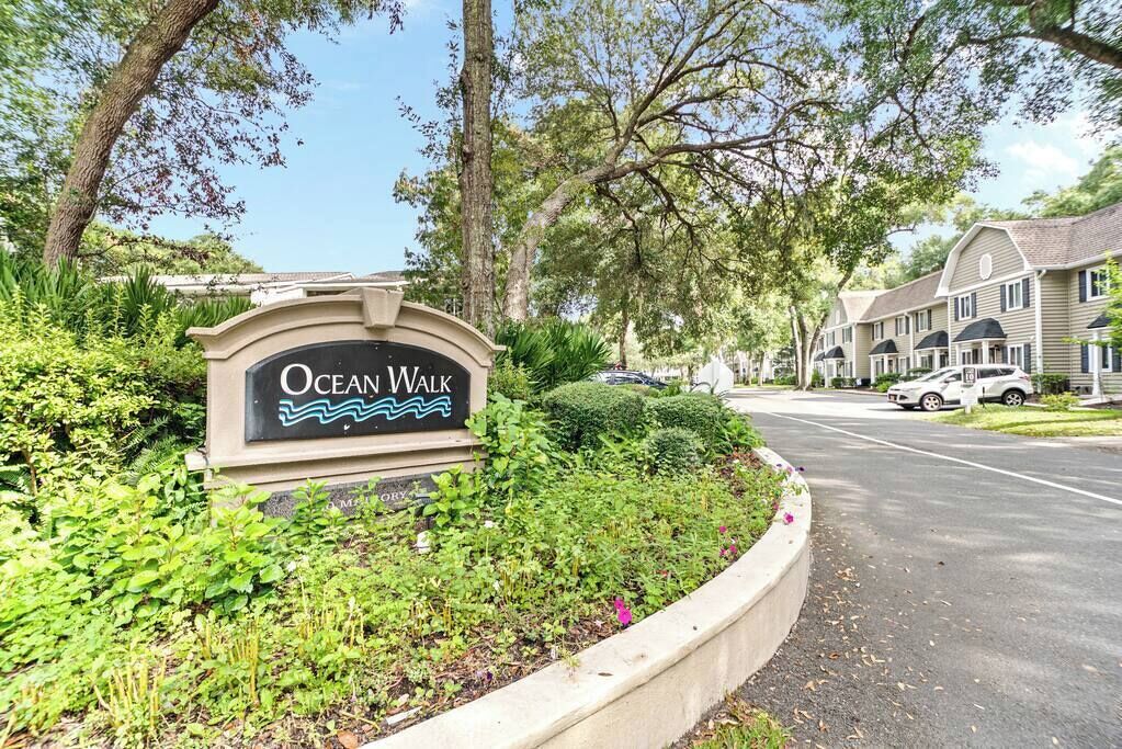 A sign for Ocean Walk, surrounded by greenery and residential buildings.