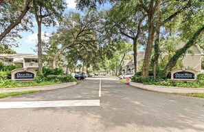 A residential street with houses, trees, and a sign reading 'Ocean Walk'.