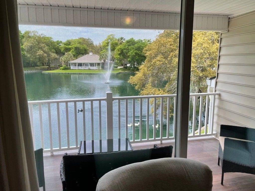 Quarto com vista para um lago, um gazebo e uma fonte.