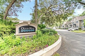 A sign for Ocean Walk, surrounded by greenery and residential buildings. - Water View - optional BIKES - Walk 2 Pier Village (St. Simons Island)