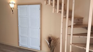 A wooden staircase with a white door and a wall-mounted light fixture.