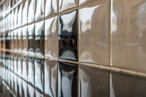 Een close-up van een glanzende, reflecterende betegelde muur met een rasterpatroon.