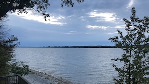 A lakeside view with a dock and a gravel path leading to the water. - Upscale Cottage - Sandbanks/Prince Edward County (Prince Edward)