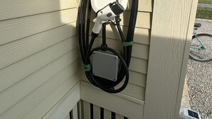 An outdoor electric vehicle charging station mounted on a wooden wall. - Upscale Cottage - Sandbanks/Prince Edward County (Prince Edward)