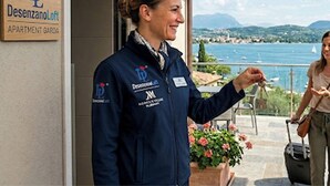 A person standing at a hotel entrance with a sign reading 'Desenzano Loft APARTMENT GARDEN'. - DesenzanoLoft : La Vite Luxury Appartment 1 (Desenzano del Garda)