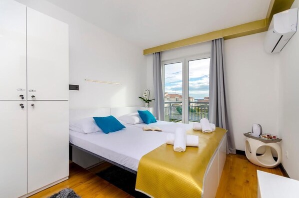 Relax in a stylish room with a large bed, white bedding, and a gold throw blanket.