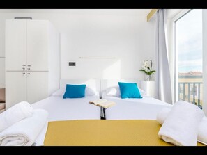Relax in a serene space with a large bed, wardrobe, and window offering a view of the outside.