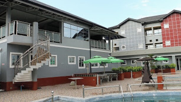A building with a pool, outdoor seating, and a staircase. - Room-all Seasons Hotel-apartment (Owerri)