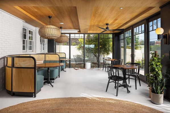 Relax in a serene space with cushioned benches, tables, and large windows offering views of the outdoors.