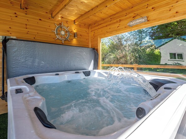 Un bain à remous avec un plafond en bois et une pancarte sur laquelle on peut lire : « Air salin ».