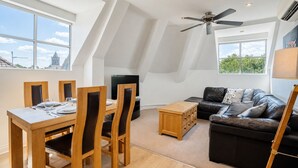 A modern loft-style living space with a dining area, a sofa, and a ceiling fan. - 7 Aspire -  a family break that sleeps 4 guests  in 2 bedrooms (York)
