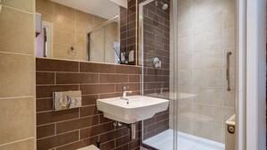 A modern bathroom with a shower, sink, and toilet. - 7 Aspire -  a family break that sleeps 4 guests  in 2 bedrooms (York)