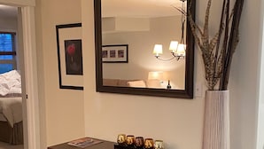 A wooden dresser with a mirror above it, a vase with branches, and a framed picture on the wall. - Top floor condo on Lake Windermere with spectacular lake and Mountain View’s (Invermere)