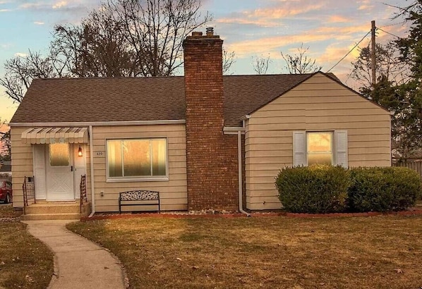 Stunning two-story home with a charming front porch and beautifully manicured garden.