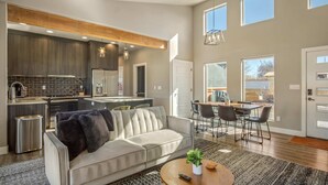 A modern kitchen with dark wood cabinets, a central island, and pendant lighting. - Private Resort with Kanab Charm 2 Bedroom, 2 Bathroom,  Pool,  Hot Tub, Stargazing Roof Deck: Timber & Tin G (Kanab)