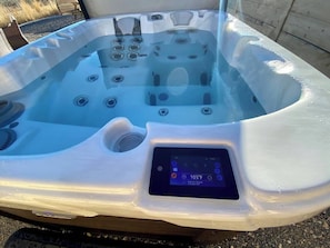 A hot tub with a control panel displaying temperature settings.