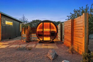 A circular wooden structure with a bench inside, surrounded by a gravel path and a wooden fence. - East Zion Designer Container Studio- Satori Zion (Orderville)