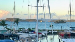 A marina with multiple boats docked, calm water, and a mountainous backdrop. - Sapphire Beach Villa (St. Thomas)