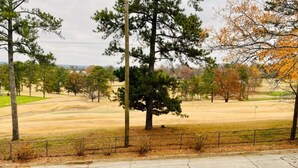 A golf course with a fence, trees, and a clear sky. - Near Downtown Stunning Course-View Flat (Birmingham)
